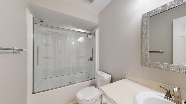 full bathroom with enclosed tub / shower combo, vanity, and toilet