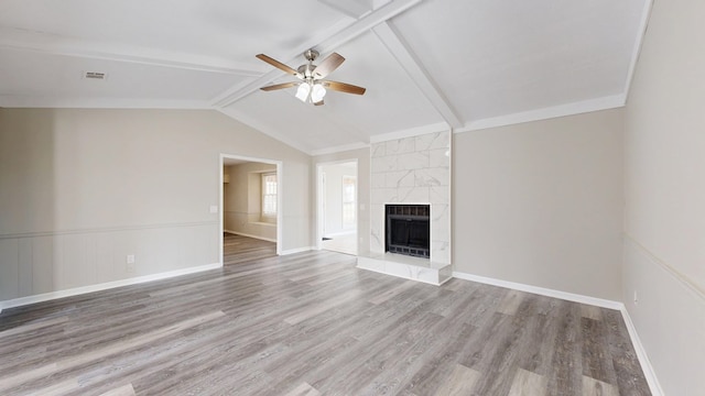 unfurnished living room with vaulted ceiling with beams, a fireplace, wood-type flooring, and ceiling fan