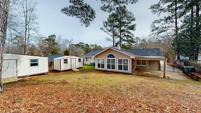 back of house featuring a storage unit, a patio area, and a lawn