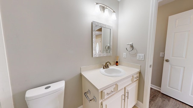 bathroom featuring vanity, toilet, and hardwood / wood-style floors