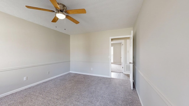 carpeted empty room featuring ceiling fan and a textured ceiling