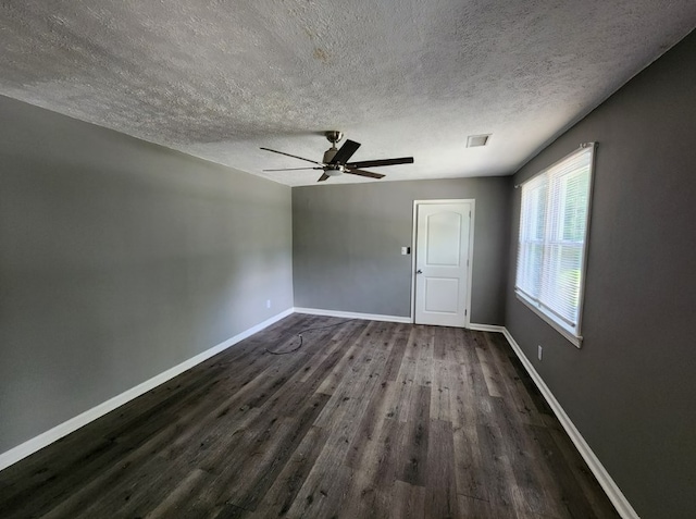 empty room with dark hardwood / wood-style floors, a textured ceiling, and ceiling fan