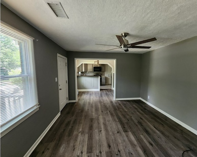 unfurnished living room featuring a textured ceiling, dark wood-type flooring, and ceiling fan