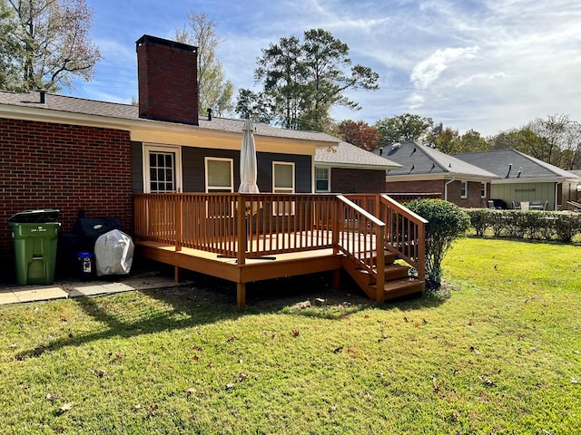 back of house featuring a yard, a wooden deck, and a chimney