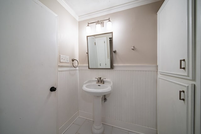 bathroom with a wainscoted wall and crown molding