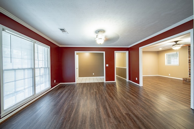spare room featuring visible vents, baseboards, ceiling fan, ornamental molding, and wood finished floors