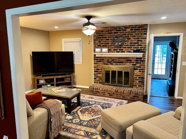 living room featuring baseboards, wood finished floors, visible vents, and ceiling fan
