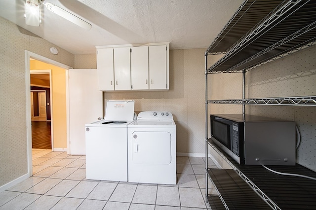 washroom featuring light tile patterned floors, wallpapered walls, cabinet space, ceiling fan, and washing machine and dryer