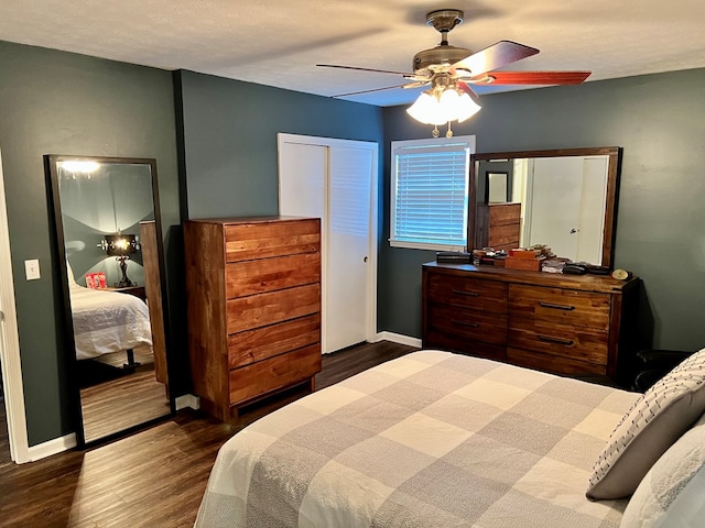bedroom with ceiling fan, dark wood-type flooring, and baseboards
