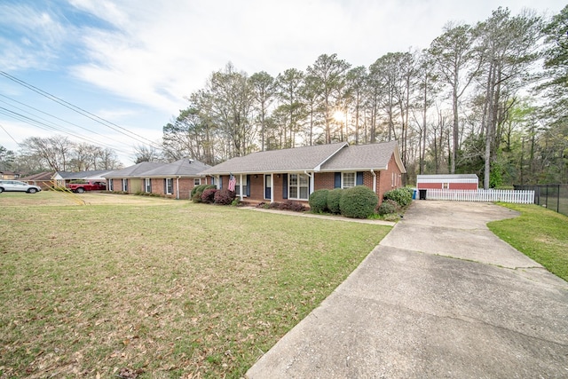 single story home with brick siding, concrete driveway, a front lawn, and fence