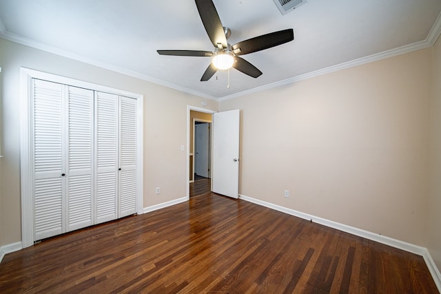 unfurnished bedroom featuring visible vents, baseboards, wood finished floors, and crown molding