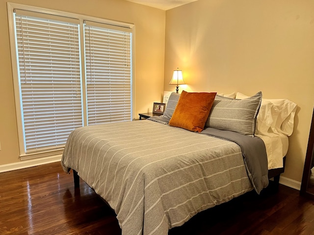 bedroom with baseboards and wood finished floors