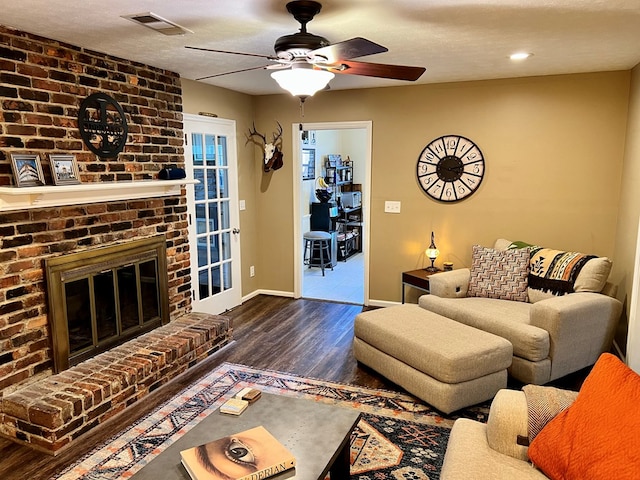 living room with visible vents, baseboards, ceiling fan, wood finished floors, and a textured ceiling