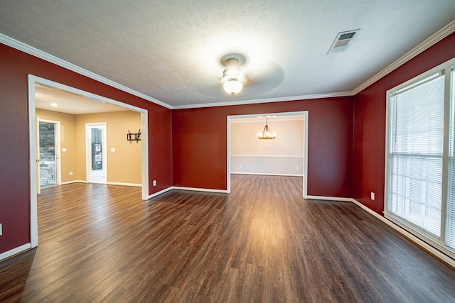 unfurnished room with visible vents, baseboards, wood finished floors, and crown molding