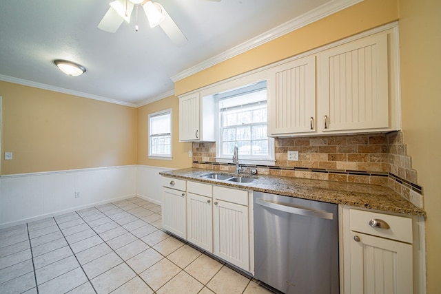 kitchen with ornamental molding, a sink, stainless steel dishwasher, wainscoting, and light tile patterned floors