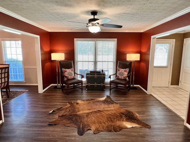 sitting room with crown molding, ceiling fan, and wood finished floors