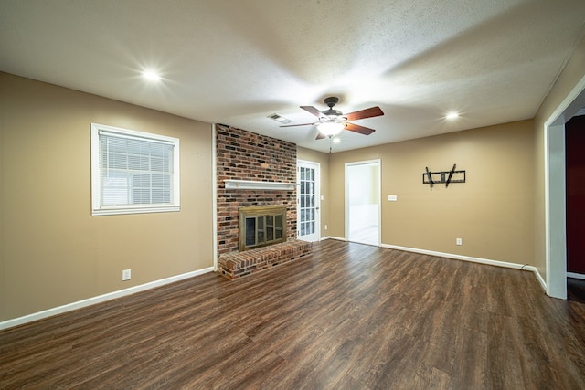 unfurnished living room featuring visible vents, a textured ceiling, dark wood-type flooring, and baseboards