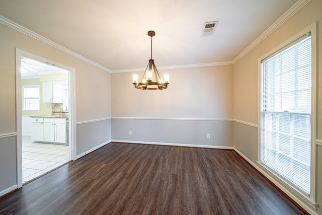 empty room with dark wood-style floors, visible vents, baseboards, an inviting chandelier, and crown molding