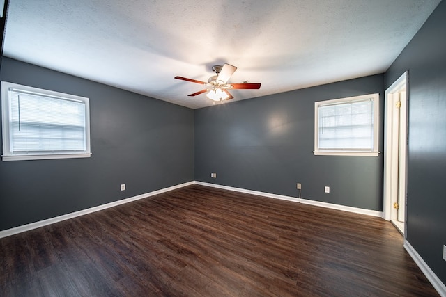 spare room with a textured ceiling, wood finished floors, baseboards, and ceiling fan