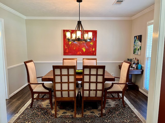 dining room with crown molding, a notable chandelier, wood finished floors, and visible vents