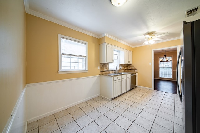kitchen with visible vents, light tile patterned flooring, a sink, stainless steel appliances, and white cabinets