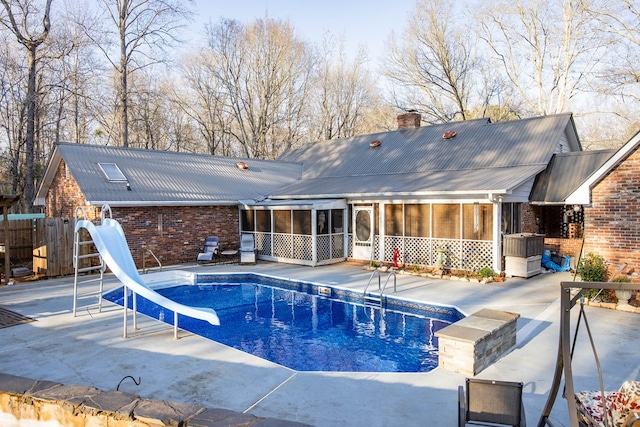 view of pool featuring a water slide, a patio area, a sunroom, and a fenced in pool