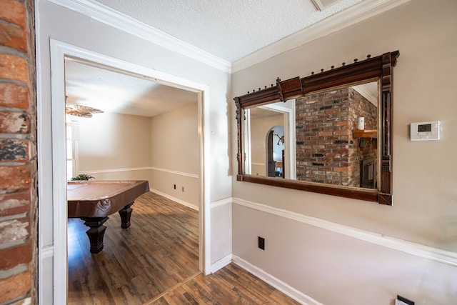 interior space with crown molding, a textured ceiling, wood finished floors, billiards, and baseboards