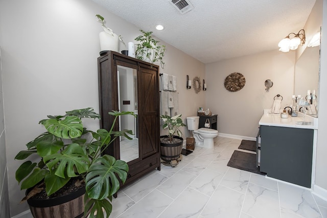 bathroom featuring a textured ceiling, toilet, visible vents, baseboards, and marble finish floor