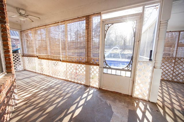 unfurnished sunroom with a ceiling fan