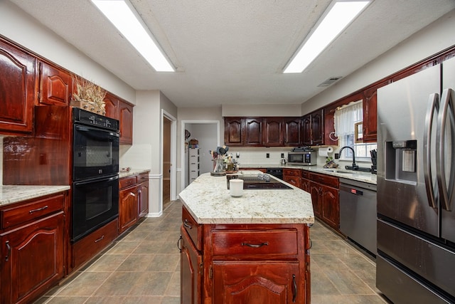 kitchen with black appliances, a kitchen island, visible vents, and dark brown cabinets