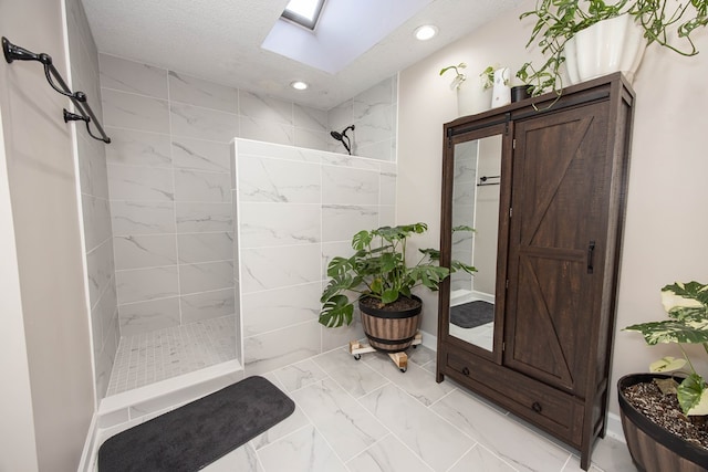 bathroom with a skylight, marble finish floor, recessed lighting, and walk in shower