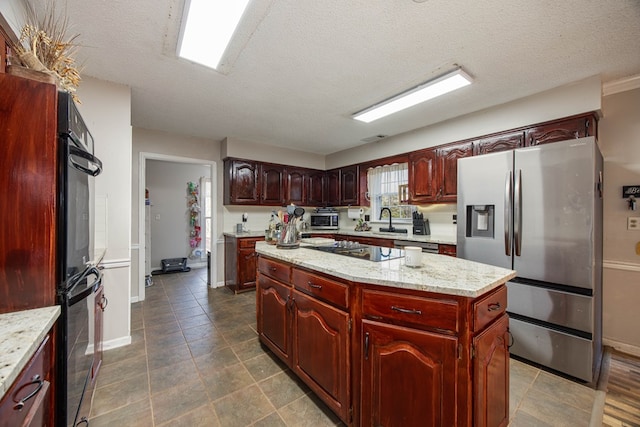 kitchen with cooktop, a toaster, stainless steel fridge with ice dispenser, a center island, and a sink