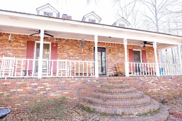 property entrance featuring a ceiling fan, covered porch, and brick siding