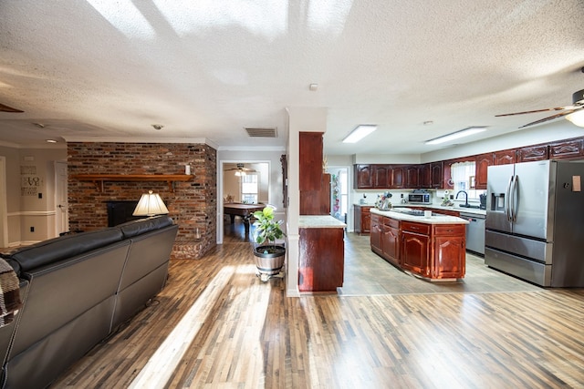 kitchen with ceiling fan, appliances with stainless steel finishes, light countertops, and open floor plan