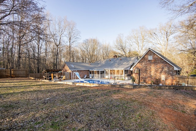 back of house with brick siding, a patio area, a fenced backyard, and a fenced in pool