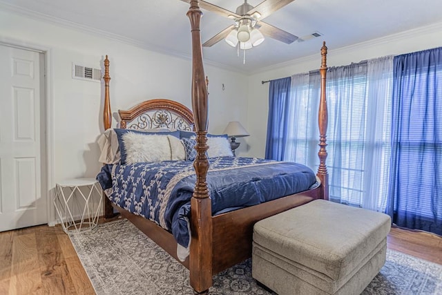 bedroom featuring hardwood / wood-style floors, ceiling fan, and crown molding