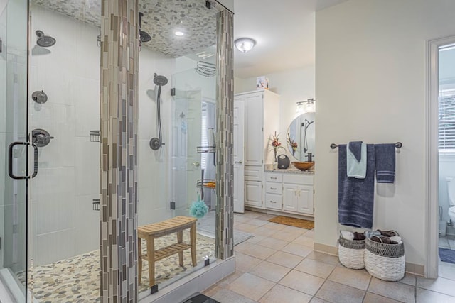 bathroom featuring toilet, vanity, tile patterned floors, and an enclosed shower