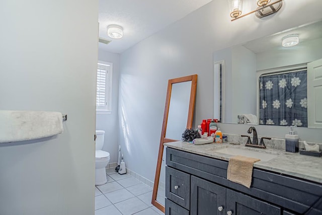 bathroom with tile patterned flooring, vanity, and toilet