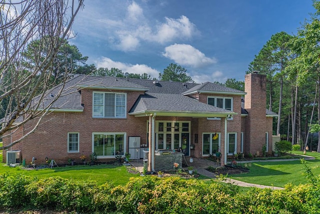 rear view of property featuring cooling unit and a lawn