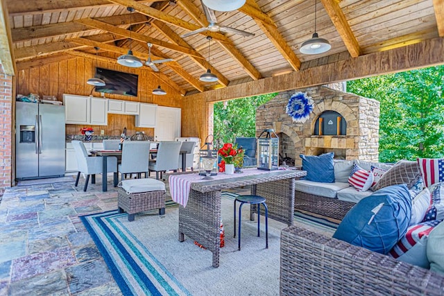 view of patio with an outdoor living space with a fireplace and ceiling fan