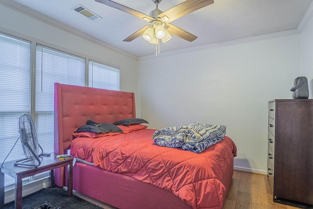 bedroom featuring ceiling fan, wood-type flooring, and ornamental molding