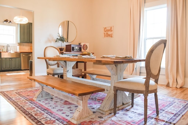 dining area with a wealth of natural light, sink, and light hardwood / wood-style floors