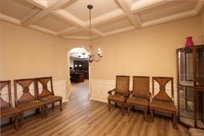 sitting room with beamed ceiling, wood-type flooring, and coffered ceiling