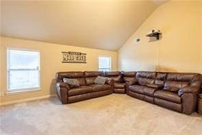 carpeted living room with a healthy amount of sunlight and vaulted ceiling