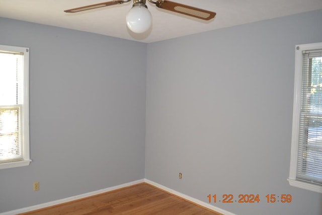 empty room with hardwood / wood-style flooring and plenty of natural light