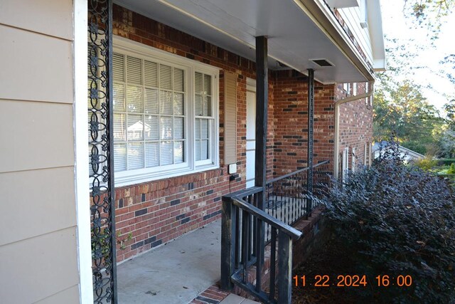 view of exterior entry featuring covered porch