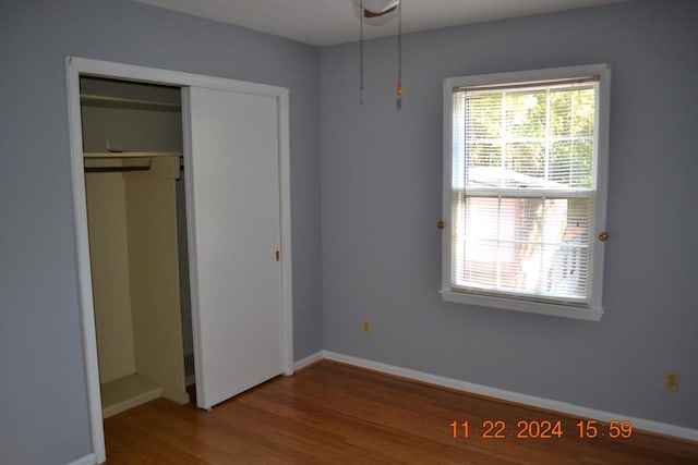 unfurnished bedroom with a closet and hardwood / wood-style flooring