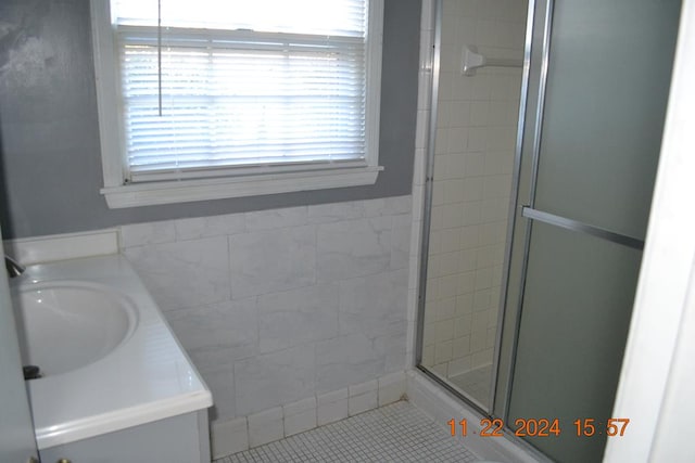 bathroom featuring tile patterned flooring, vanity, and an enclosed shower