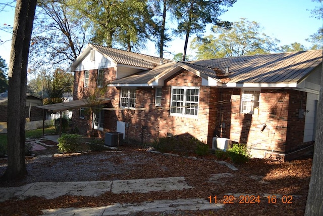 view of side of home with central AC unit and a carport