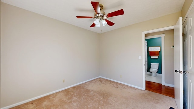 unfurnished room with a ceiling fan, light colored carpet, and baseboards